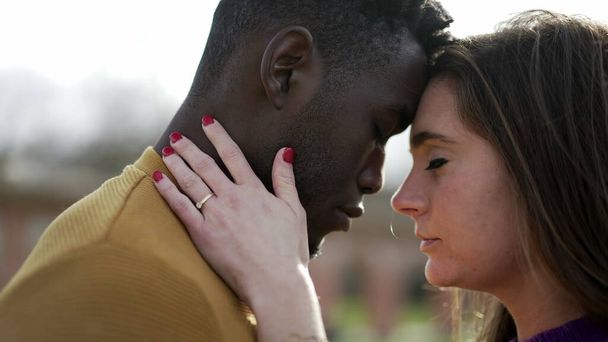Hermoso momento entre dos amantes interracial juntos de pie fuera con afecto y amor - Foto, imagen