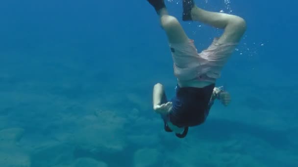 Πρόσωπο με μάσκα κατάδυσης και πτερύγια που κολυμπάει κάτω από το νερό - Πλάνα, βίντεο