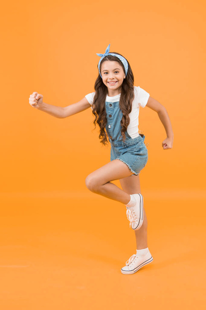 Active lifestyle. Girl long curly hair tied headscarf. Hair care. Energy inside. Vacation time. Fashion trend. Little fashionista yellow background. Cute kid fashion girl. Summer fashion concept. - Φωτογραφία, εικόνα