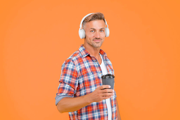 Good to the last drop. Happy man hold coffee cup yellow background. . Takeaway drink. Hot drink. Coffee break. Modern technology. Music and fun. Morning habit. When you just feel like it. - Foto, immagini
