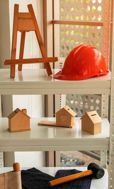 Orange construction helmet on wooden shelf. Safety helmet store on rack Accessories - Fotó, kép
