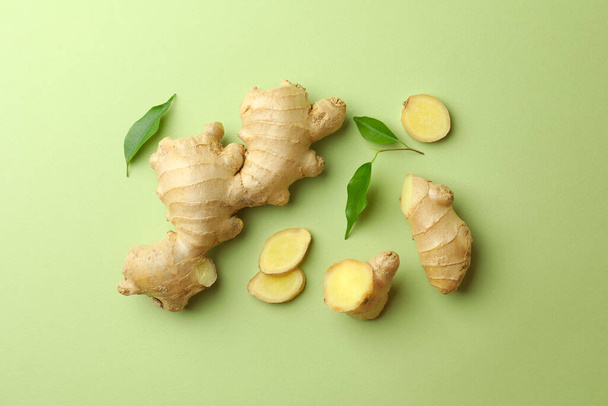 Fresh ginger with leaves on light pale green background, flat lay - Φωτογραφία, εικόνα