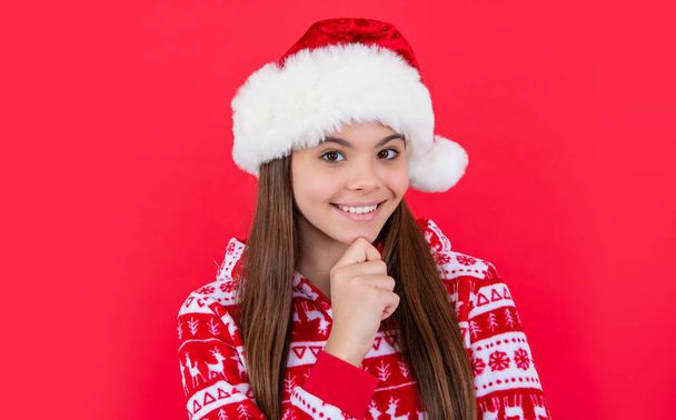 happy new year. smiling teen girl in red new year santa hat in studio. teen santa new year girl isolated on red background. - Foto, Imagen