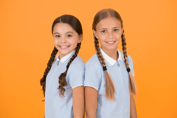 old school fashion. back to school. happy beauty with pigtails. happy childhood. brunette and blond hair. sisterhood concept. best friends. vintage style. small girls in retro uniform. at hairdresser. - Foto, Bild
