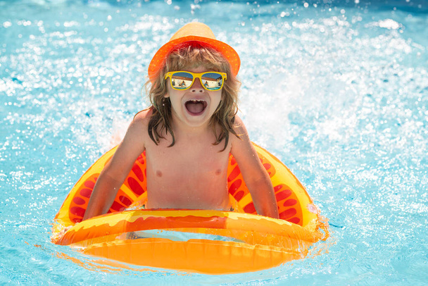 Kids swim swimming pool. Summer vacation concept. Summer kids portrait in sea water on beach. Blue water poolside - Фото, изображение