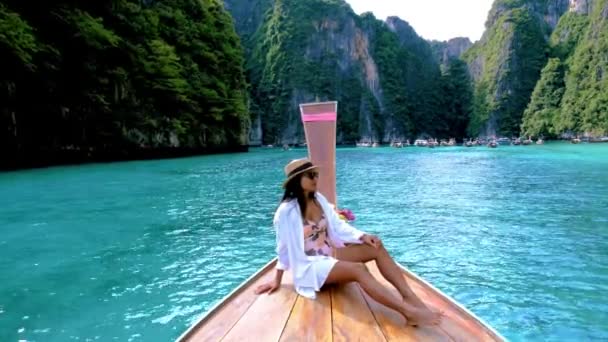 Ταϊλανδέζες μπροστά από το πλοίο longtail στη λιμνοθάλασσα Pileh με το πράσινο σμαραγδένιο ωκεανό στο Koh Phi Phi Ταϊλάνδη,  - Πλάνα, βίντεο