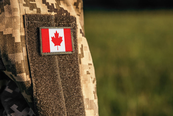 Nahaufnahme einer Millionärin oder eines Millionärs auf dem Arm mit einem Aufnäher der kanadischen Flagge. Kanada Truppen Armee, Soldat Tarnuniform. Streitkräfte, leerer Kopierraum für Text - Foto, Bild