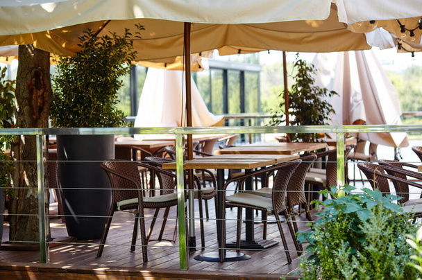 Restaurant terrasse parasol avec ampoules. Extérieur moderne du café d'été. Image floue, focus sélectif - Photo, image