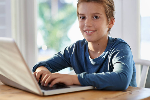 Технологии для всей семьи. Портрет улыбающегося мальчика с ноутбуком дома - Фото, изображение