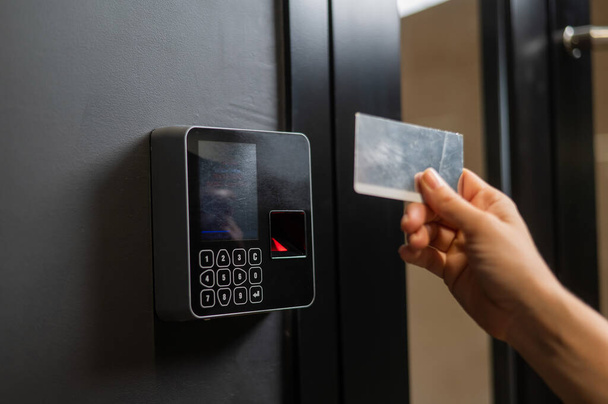 A woman opens the door with a plastic card. Modern keyless entry lock - Foto, afbeelding