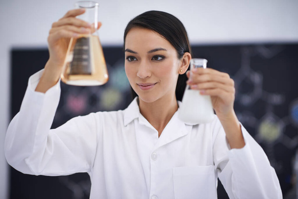 Which beaker is the right one. a female scientist observing liquids in conical beakers - Photo, Image