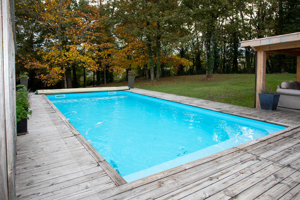 дерев'яний куточок басейну з блакитною водою
 - Фото, зображення
