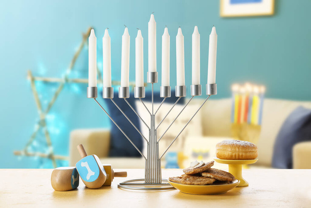 Menorah com dreidels e comida para Hanukkah na mesa no quarto - Foto, Imagem