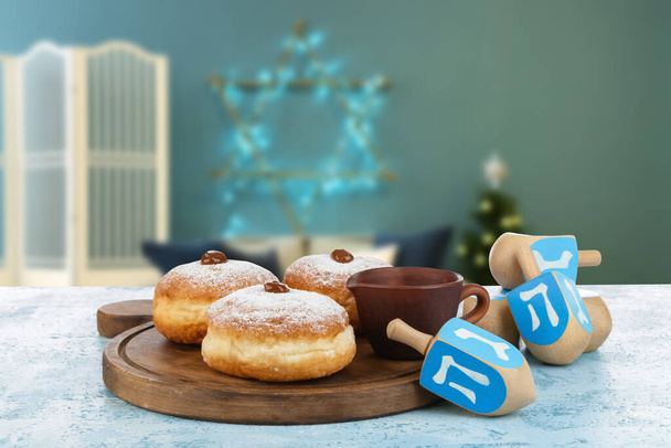 Donuts e dreidels para Hanukkah na mesa no quarto - Foto, Imagem