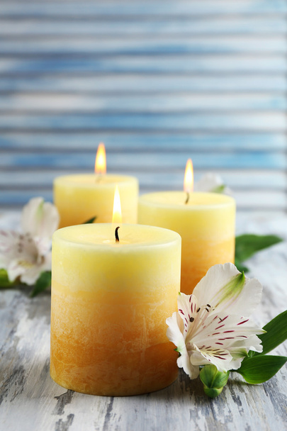 Beautiful candles with flowers on wooden background - Photo, image
