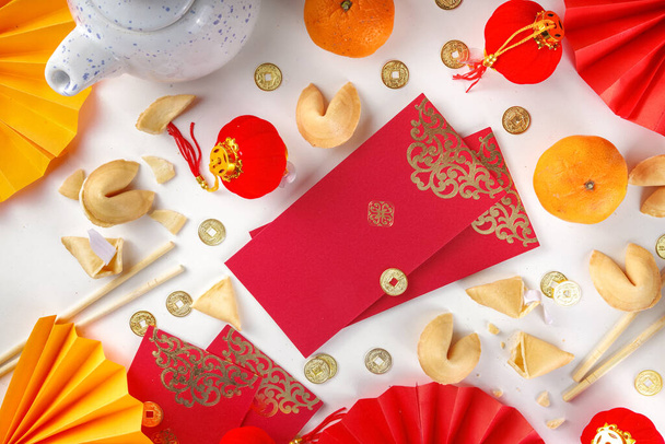 Kiinalainen uusi vuosi tausta. Punainen ja kullankeltainen flatlay perinteinen kiinalainen uusi vuosi sisustus, kirjekuoret toiveita, kultakolikoita, fanit, Kiinan lyhdyt, appelsiinit ja teetä - Valokuva, kuva