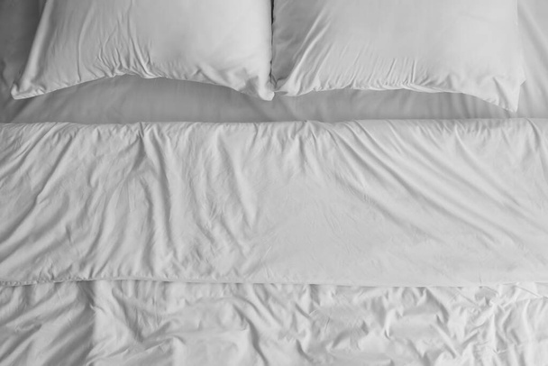 Witte lakens en kussens op bed, close-up - Foto, afbeelding