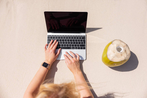 Nő dolgozik laptop számítógép a trópusi strandon, kilátás felülről - Fotó, kép