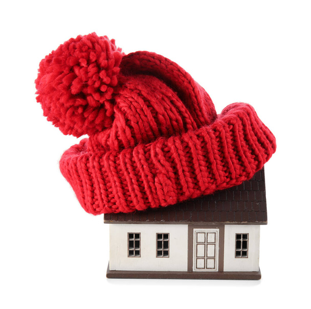 Модель дома в красной шляпе на белом фоне. Концепция нагрева - Фото, изображение