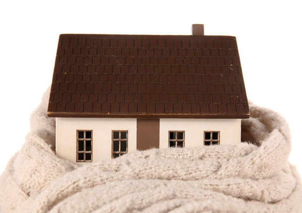 Modello di casa con sciarpa su sfondo bianco. Concetto riscaldamento - Foto, immagini