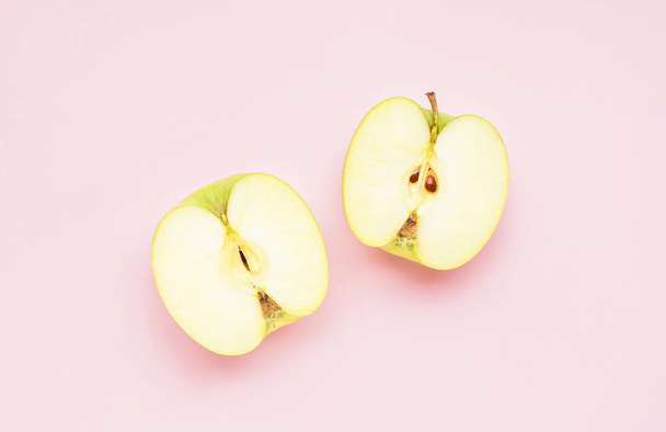 Pembe arka planda olgun elma yarımları - Fotoğraf, Görsel