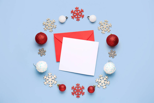 Composition with blank card, envelope and beautiful Christmas decorations on light background - Photo, Image