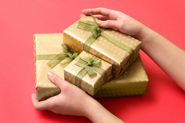 Nő karácsonyi ajándék dobozok piros háttér, közelkép - Fotó, kép
