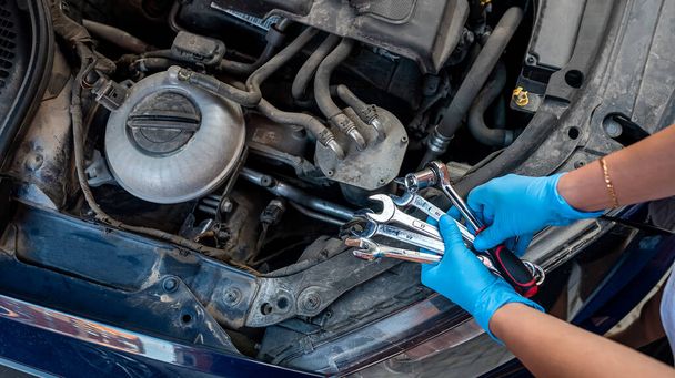 car mechanic works in a garage to repair a car. Repair services. - Photo, Image