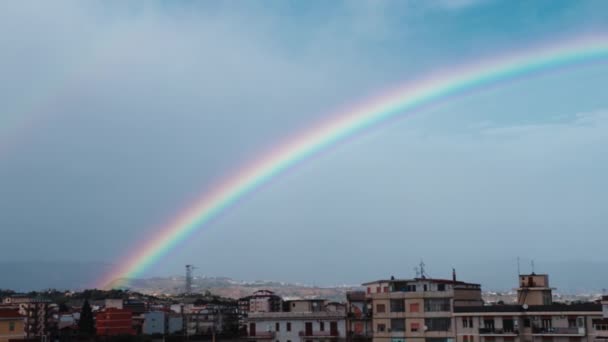 Hermosos colores del arco iris en el cielo durante el día lluvioso - Imágenes, Vídeo