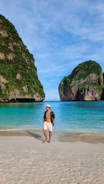 giovani uomini abbronzanti con pantaloncini da bagno e un cappello sulla spiaggia di Maya Bay Koh Phi Phi Thailandia.  - Foto, immagini