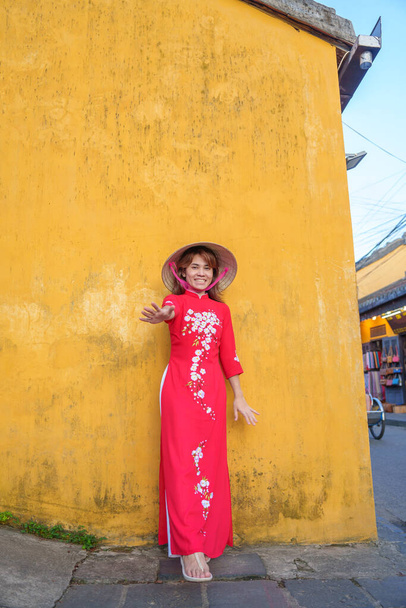 счастливая женщина в вьетнамском платье и шляпе Ао Дай, путешественник осматривает достопримечательности Хоя древнего города в центральной части Вьетнама. ориентир и популярны для туристических достопримечательностей. Вьетнам и Southern Travel - Фото, изображение