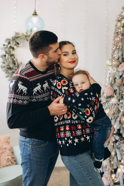 Portret van een gelukkige familie van vader moeder en kleine krullende zoon vieren Kerstmis samen thuis. Nieuwjaarsavond concept. - Foto, afbeelding