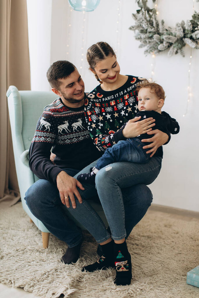 Anne ve babanın mutlu aile portresi ve evde birlikte Noel 'i kutlayan kıvırcık oğlan. Yeni yıl arifesi konsepti. - Fotoğraf, Görsel