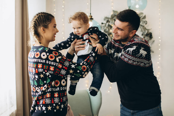 Портрет щасливої сім'ї батька матері і маленького кучерявого сина, який святкує Різдво разом вдома. Новорічна концепція
. - Фото, зображення