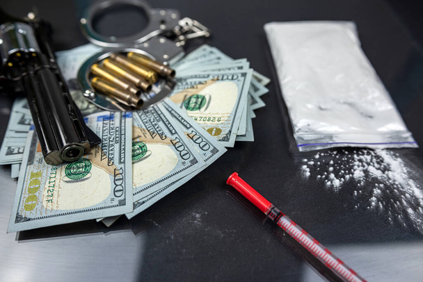 Ναρκωτικά και όπλα με σιγαστήρα και χειροπέδες σε μαύρο φόντο. Πουλάω ναρκωτικά. παραβίαση του νόμου - Φωτογραφία, εικόνα