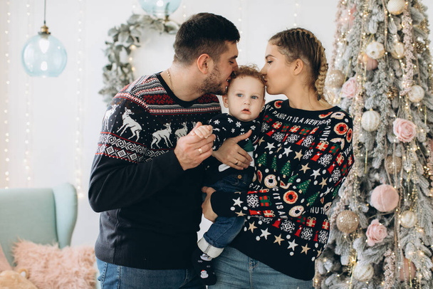 Portrait of happy family of father mother and little curly son celebrating Christmas together at home. New Year`s Eve concept. - Fotó, kép
