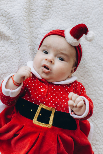 Portret van een grappig klein meisje in kerstkleren - Foto, afbeelding