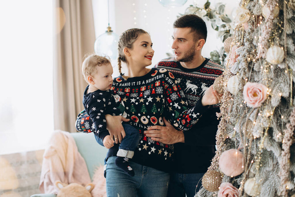 Retrato de familia feliz de padre madre y pequeño hijo rizado celebrando la Navidad juntos en casa. Concepto de Nochevieja. - Foto, Imagen