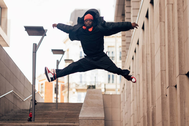 artiste breakdance hip hop à la mode performer sauter à bras ouverts concept de style de vie urbain - Photo, image