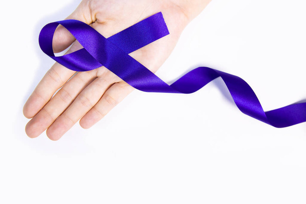 Blue satin ribbon bow on hand isolated over white background. - Photo, image