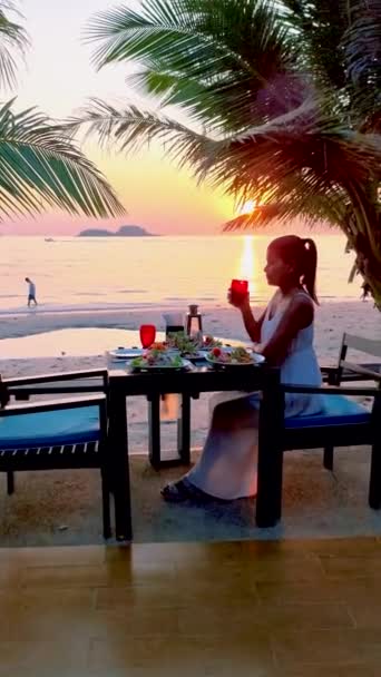 Aasian Thai naiset auringonlaskun aikana illallinen rannalla Koh Chang Thaimaa. - Materiaali, video