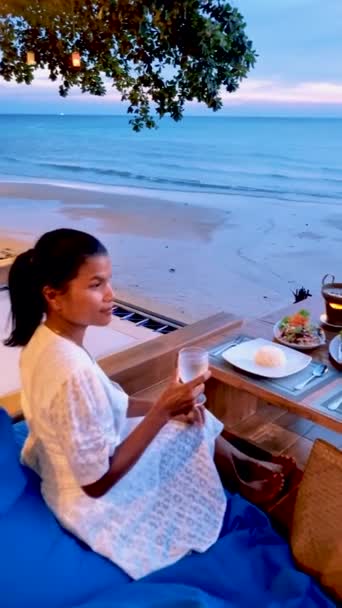 Asijské thajské ženy při západu slunce s večeří na pláži Koh Chang Thajsko během dovolené na pláži. - Záběry, video