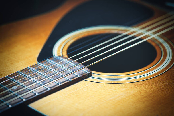 Акустична гітара з новими струнами на чорному тлі
 - Фото, зображення