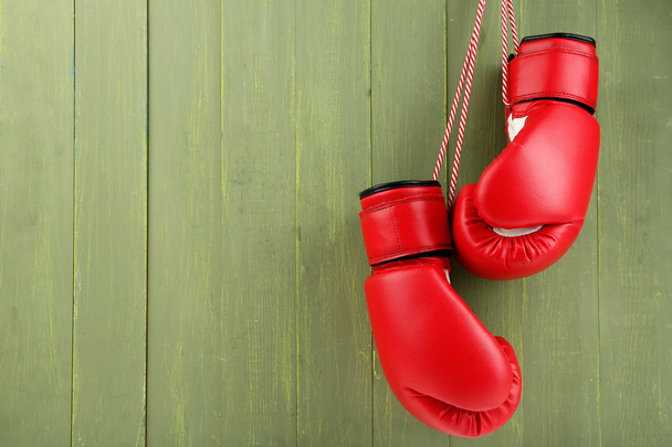 Pair of boxing gloves on color wooden background - Φωτογραφία, εικόνα