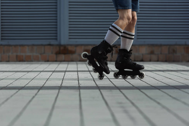 Vue recadrée de l'homme en chaussettes de genou et patins à roulettes à l'extérieur  - Photo, image
