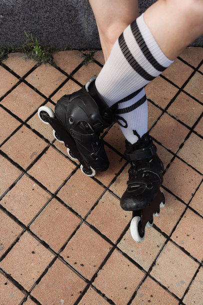 Вид зверху на ноги молодого чоловіка в шкарпетках і роликах на відкритому повітрі
  - Фото, зображення