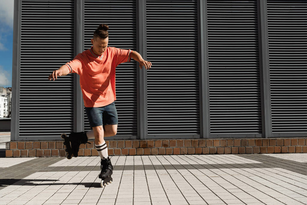 Focused roller skater riding on one leg on urban street  - Фото, изображение