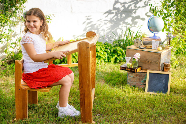 Školačka za stolem na ulici se připravuje ke studiu na Montessori škole. Lekce venku. NAZad do školy - Fotografie, Obrázek