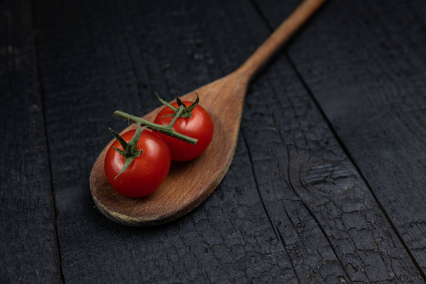 Wooden spoon on a dark background with vegetables - Valokuva, kuva