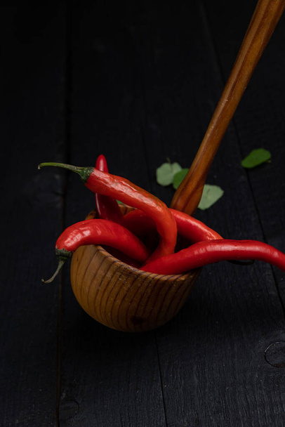 Wooden spoon on a dark background with vegetables - Foto, Imagem